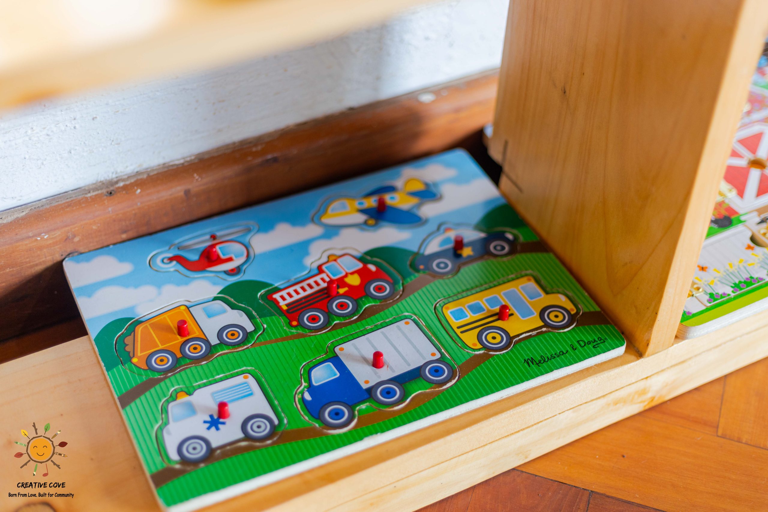 A close-up of a wooden vehicle peg puzzle